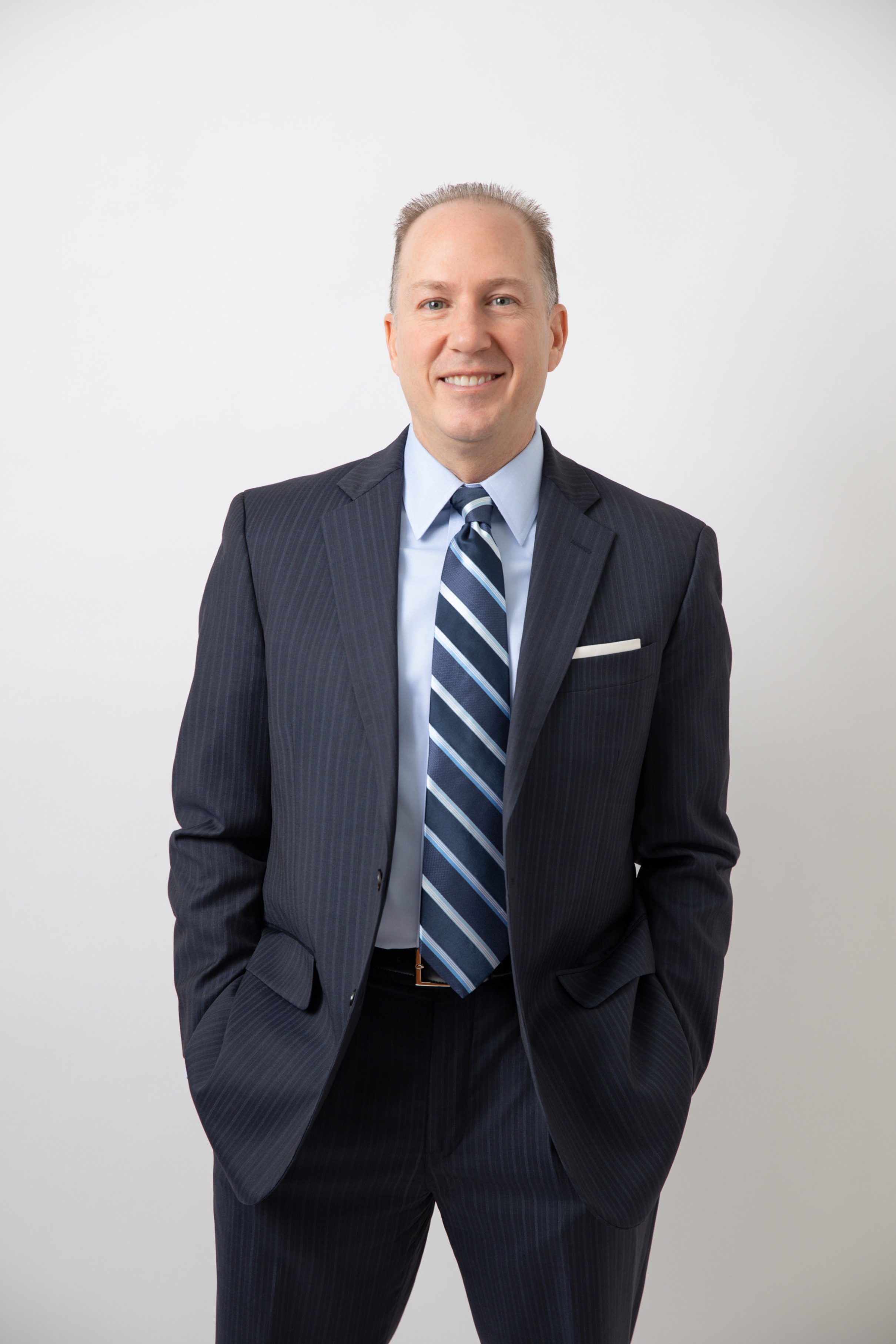 Portrait of Greg Woods in a navy suit